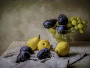 Miska z winogronem figami i gruszkami na stole