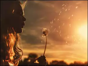 Kobieta rozdmuchująca dmuchawiec w blasku zachodzącego słońca