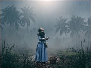 Dziewczyna w palmowym lesie podczas deszczu