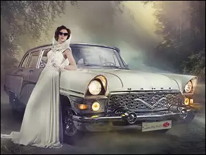 Kobieta w stylu retro oparta o samochód Gaz-13 Czajka