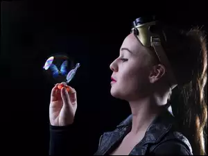 Kobieta dmucha na bańkę mydlaną z motylkiem