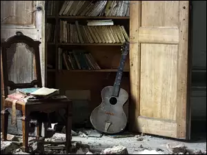Krzesło obok półki z książkami w zniszczonym pomieszczeniu