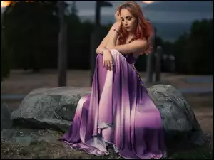 Kobieta w sukni na kamieniu