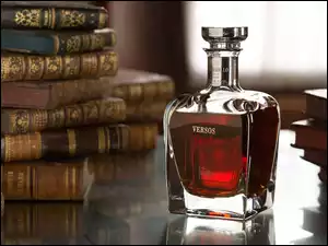 Butelka whisky stoi między książkami