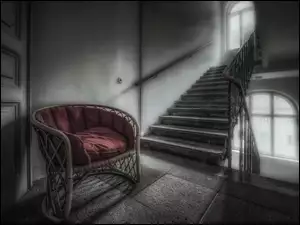 Fotel z poduszką przy schodach z oknem