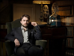 Daniel Radcliffe siedzący na fotelu przy starym projektorze