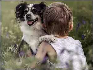 Chłopczyk i jego pies w czułym uścisku