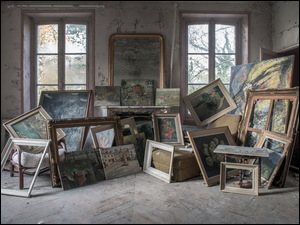 Stare zniszczone wnętrze pokoju z obrazami i ramami do obrazów