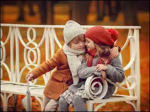 Chłopiec z dziewczynką przytulni na ławce w parku