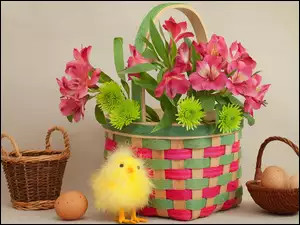Kurczaczek i jajka w koszyczku obok bukietu kwiatów w koszyku