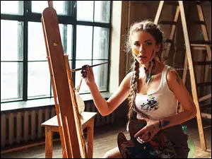 Dziewczyna z warkoczami malująca obraz