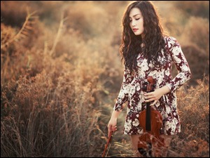 Kobieta ze skrzypcami na łące