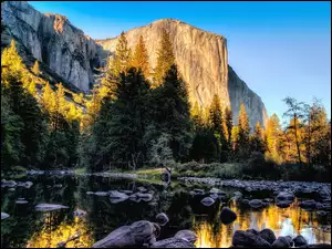 Góry i rzeka w promieniach słońca w kalifornijskim Parku Narodowym Yosemite