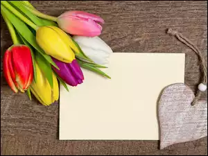 Kolorowe tulipany na kopercie obok serca na sznurku