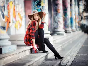 Modelka w kapeluszu na schodach