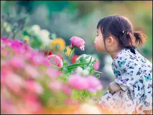 Dziewczynka dmucha na kwiaty