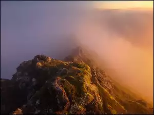 Przebijające światło w górach we mgle