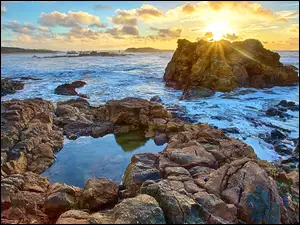 Promienie słońca na morskich skałach