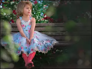 Dziewczynka w sukience na ławce