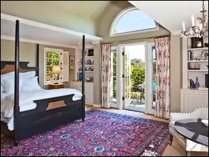 Pokój z kolorowym dywanem i dużym łóżkiem