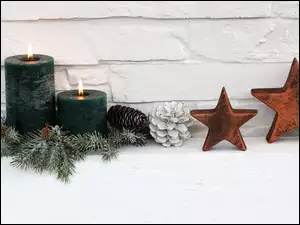 na białym tle stroik świąteczny z świecami i gwiazdkami