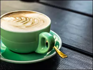 Kawa Cappuccino w zielonej filiżance z talerzykiem i łyżeczką