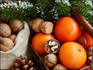 Worek z orzechami obok pomarańczy w sklepowym koszyku