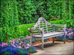 Drewniana ławeczka obok klombów z kwiatami w parku w Dallas