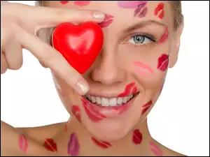 Uśmiechnięta kobieta z sercem z szminkowych pocałunkach z dłonią