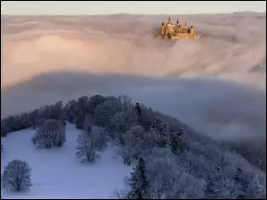 Zamek Hohenzoller w mglistych górach leśnych ośnieżonych