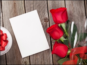 Róże z kokardą kieliszkami i kartką