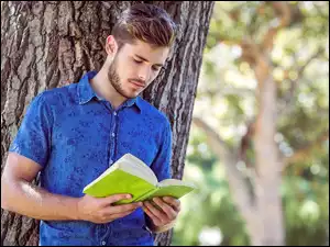 Przystojny mężczyzna czytający książkę