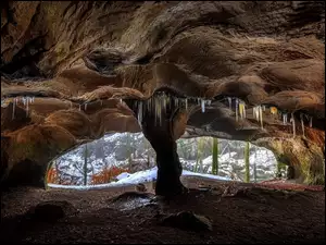 Jaskinia skalna z soplami i śniegiem
