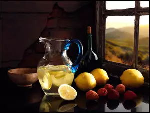 Dzbanek z napojem cytrynowym obok owoców stoliku przy oknie