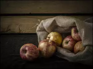 Jabłka w worku na deskach