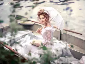 Kobieta z parasolką w łódce