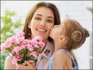 Uśmiechnięta kobieta z dziewczynką i kwiatami