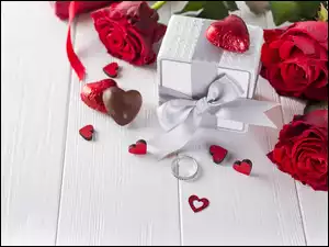 Czerwone róże z prezentem serduszkami i pierścionkiem