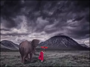 Chłopiec z czerwoną parasolką obok słonia
