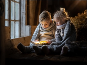 Dziewczynka i chłopczyk czytają książkę