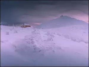 Budynek w górach przysypany śniegiem
