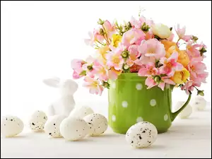 Zajączek i jajka obok bukietu kwiatów w filiżance