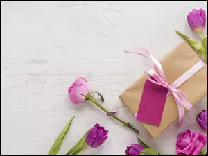 Tulipany ułożone wokół prezentu z bilecikiem