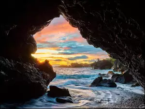 Wschód słońca nad morską skalną jaskinią