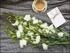 Filiżanka kawy z bukietem białych kwiatów