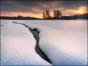 Woda płynąca między zaspami śnieżnymi