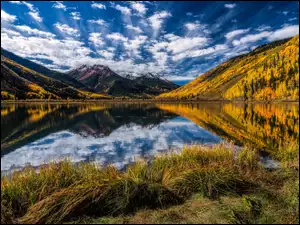 Górskie jezioro z jesiennym lasem
