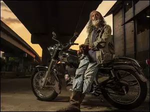 starzec z motorem na ulicy