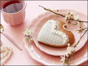 Serce z piernika na talerzu obok filiżanki kawy