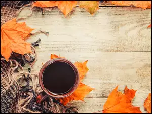 Filiżanka z kawą obok koca i jesiennych liści